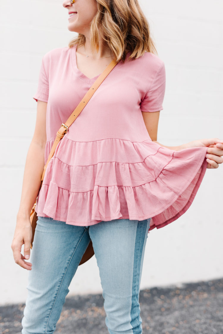 A casual feminine look full of Fall's biggest trends - blush top, step hem jeans, a round bag, and block heels.